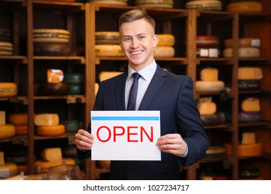 Business owner holding "OPEN" sign in his store - Powered by Shutterstock