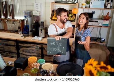 Business owner holding Open Sign. Proud couple opening their store
 - Powered by Shutterstock