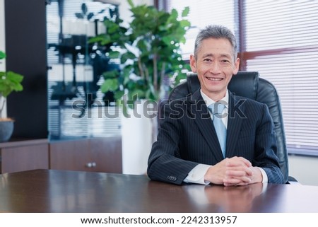 A business owner man sitting in his chair with a smile on his face