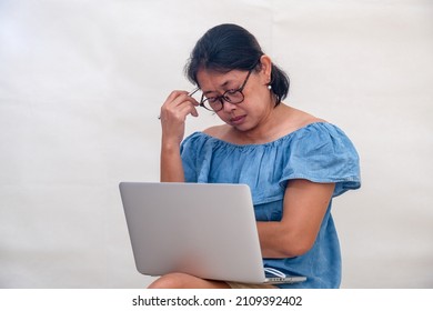 A business owner with a tab on her lap, her head lowered, eyes closed. She tries to have a little rest during her hectic day.
