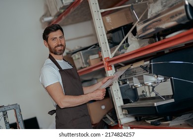 Business Owner Working On Warehouse With Different Coffee Machines