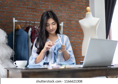 business owner,Fashion designer drawing new sketches collection and use needle in garment collection dummy. young Asian woman dressmaker working in Designers Stylish tailors studio Showroom  workshop - Powered by Shutterstock