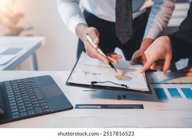 Business partners analyzing financial data, collaborating on charts and graphs, and planning for growth and success in the office using laptops and technology - Powered by Shutterstock