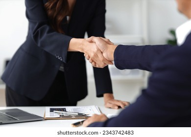 Business partners and colleagues shaking hands at work cooperation. Job applicant shaking hands with executives in office room at job interview.