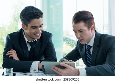 business partners discussing documents and ideas at meeting - Shutterstock ID 259209233