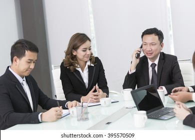 Business Partners Discussing Documents And Ideas At Meeting And Talking On The Phone At The Same Time.call Interrupt Concept. 