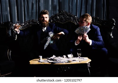 Business Partners, Elite, Superior Persons Wasting Money In Club. Man Throwing Cash, Money, Banknotes. Luxury Life Concept. Men In Suit, Businessmen Sit In Dark Luxury Interior Background.