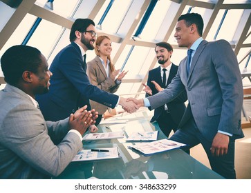 Business Partners Handshaking After Signing Contract