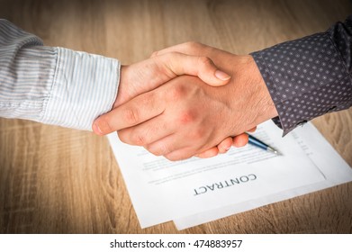 Business partners handshaking over successful conclusion of the business contract - Shutterstock ID 474883957