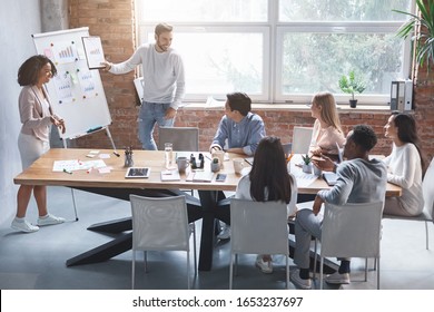 Business Partners Man And Woman Making Presentation For Young Creative Team In Modern Office, Free Space