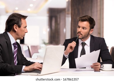 Business partners meeting. Two confident business people in formalwear discussing something while sitting at the restaurant - Powered by Shutterstock