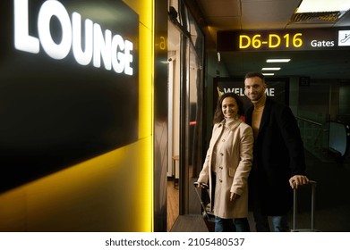 Business Partners, Multiracial Couple Of A Middle Aged Woman And Man With Suitcases Smiling Looking At Camera At The Entrance To The Duty-free Area Of The Departure Terminal Of International Airport