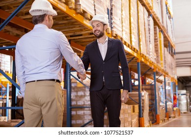 Business partners. Positive joyful men smiling while greeting each other - Powered by Shutterstock