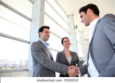 Business Partners Shaking Hands In Meeting Hall