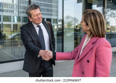 Business partners shaking hands standing in front of company office, couple of business person satisfied by the agreement, successful entrepreneurs deal - Powered by Shutterstock