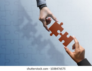 Business Partnership Or Teamwork Concept. Hands Of Two People Try To Fit Or Conncet Jigsaw Puzzle Piece Together. Top View