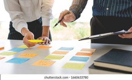 Business People Arranging Sticky Notes Commenting And Brainstorming On Work Priorities Colleague In A Modern Co-working Space