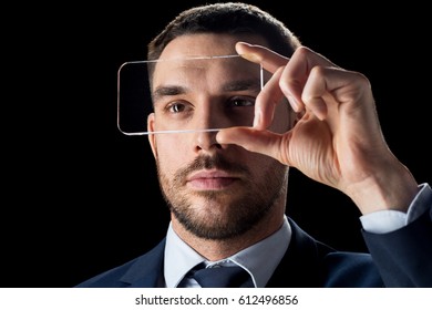 business, people, augmented reality and modern technology concept - businessman in suit working with transparent smartphone over black background - Powered by Shutterstock