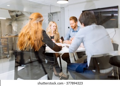 Business People Board Meeting In Modern Office While Sitting At Round Table