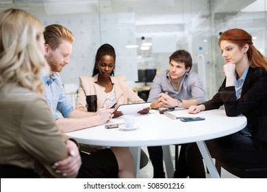 Business People Board Meeting In Modern Office While Sitting At Round Table