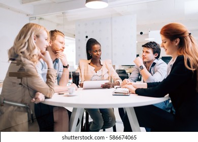 Business People Board Meeting In Modern Office While Sitting At Round Table