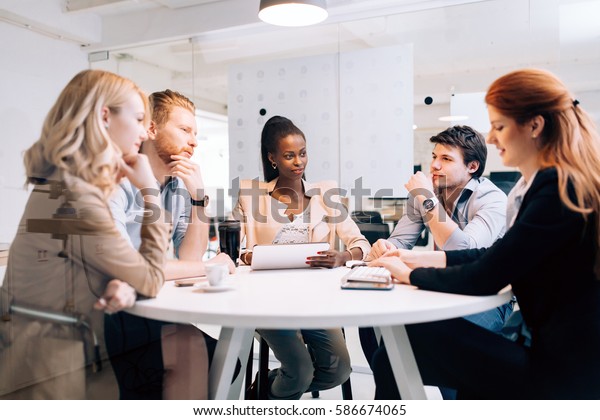 Business people board meeting in modern office\
while sitting at round\
table