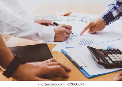 Business people brainstorming at office desk, they are analyzing financial reports and pointing out financial data on a sheet
 - Shutterstock ID 613608593