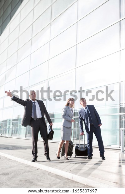 Business people\
calling for taxi in the\
airport