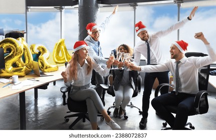 Business people are celebrating holiday in modern office drinking champagne and having fun in coworking. Merry Christmas and Happy New Year 2024 - Powered by Shutterstock