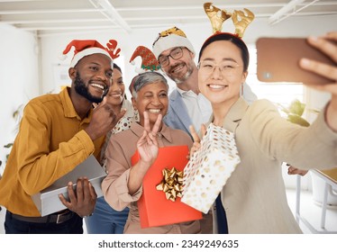 Business people, Christmas selfie and staff for smile, present or peace sign for celebration, diversity or party. Men, women and photography for funny xmas memory, friends or gift for social media - Powered by Shutterstock