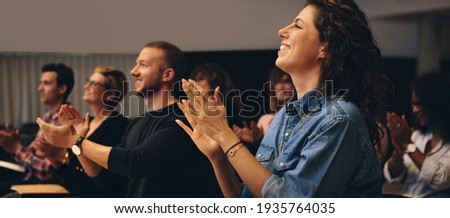 Business people clapping hands during a conference. Business professionals applauding at a seminar.
