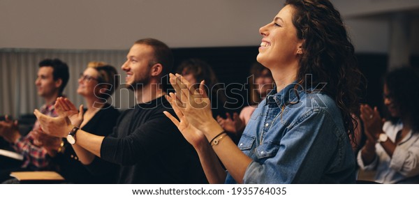 Business people clapping hands\
during a conference. Business professionals applauding at a\
seminar.