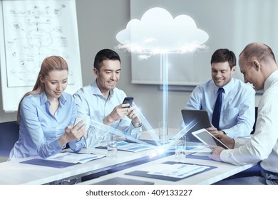 Business-, People-, Cloud-Computing- und Technologiekonzept - lächelndes Geschäftsteam mit Smartphones, Tablet PC-Computern im Büro
