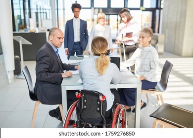 Business people with colleague in a wheelchair in a project meeting for inclusion - Shutterstock ID 1759276850
