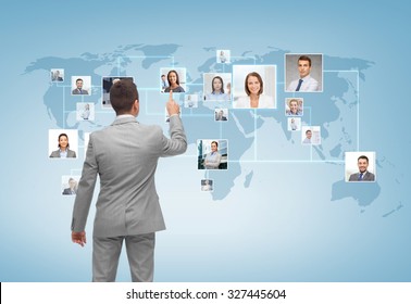 business, people, communication and technology concept - businessman pointing finger to contact icons on world map over blue background from back