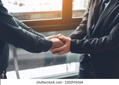 Business People Compassionately Holding Hands At Office Room.