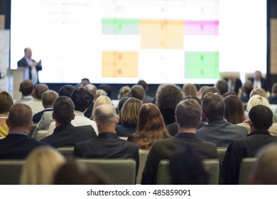 Business People Concept And Ideas. Large Group Of People At The Conference Watching Presentation Charts On Screen In Front Of Them. Horizontal Shot