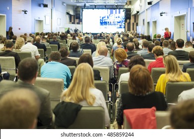 Business People Concept And Ideas. Large Group Of People At The Conference Watching Presentation On A Big Screen. Horizontal Shot