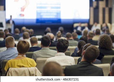 Business People Concept And Ideas. Large Group Of People At The Conference Watching Presentation Charts On Screen In Front Of Them. Horizontal Image