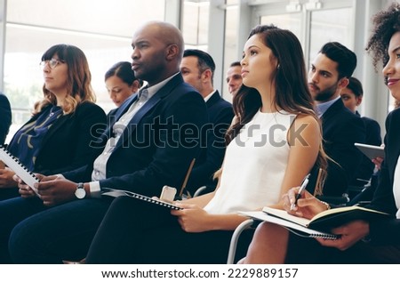 Business people, conference and audience in workshop training taking notes for team marketing or sales. Employee workers listening to coaching, presentation or meeting seminar for business strategy