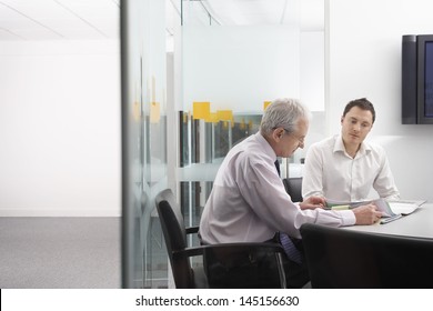 Business People In Conference Room Reviewing Documents