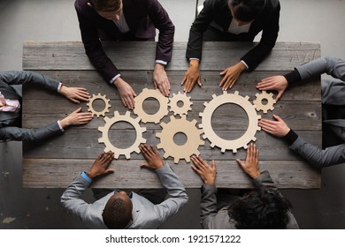 Business people connect golden gear together at meeting table, success cooperation teamwork concept