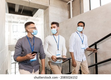 Business, People And Corporate Concept - Businessmen In Masks With Name Tags Walking Up Office Stairs And Talking