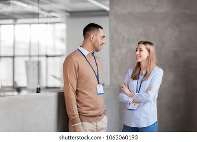 business, people and corporate concept - happy smiling man and woman with conference badges at office - Shutterstock ID 1063060193