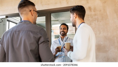 Business, People And Corporate Concept - Happy Smiling Businessmen Or Male Colleagues With Name Tags Drinking Takeaway Coffee At Office