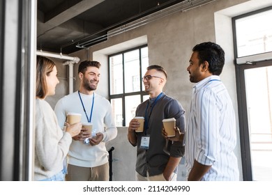 Business, People And Corporate Concept - Happy Smiling Colleagues With Name Tags Drinking Takeaway Coffee At Office