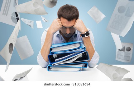 Business, People, Deadline, Stress And Paperwork Concept - Sad Businessman With Stack Of Folders And Falling Papers Over Blue Background