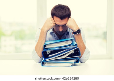 Business, People, Deadline, Stress And Paperwork Concept - Sad Businessman With Stack Of Folders At Office