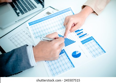 Business people discussing the charts and graphs showing the results of their successful teamwork - Shutterstock ID 245507515