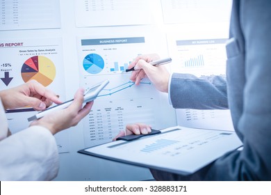 Business people discussing the charts and graphs showing the results of their successful teamwork - Shutterstock ID 328883171